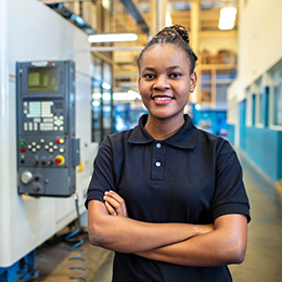 A worker with their arm crossed smiling